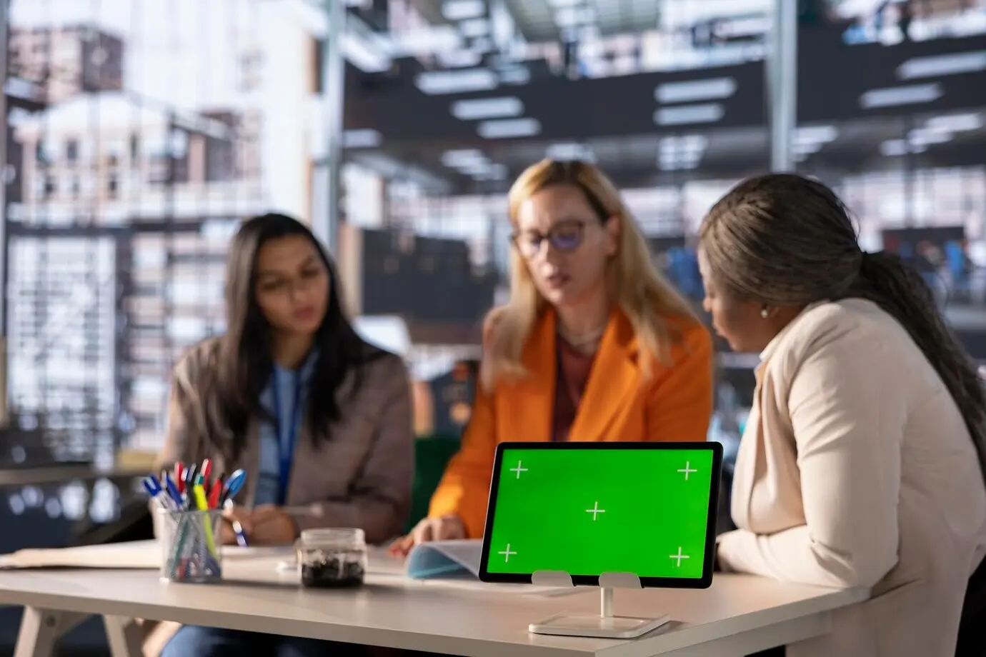 Разные бизнесвумен разрабатывают стратегию в профессиональном офисе с зелёным экраном.